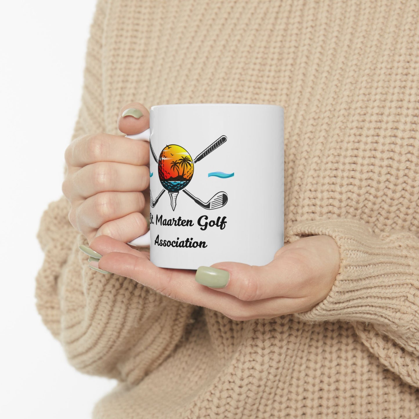 Person holding a white mug with a golf-themed design and text.