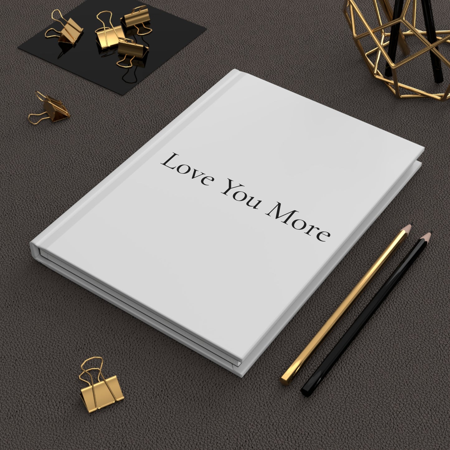 Journal lifestyle image with white cover and "Love you More" written on the cover