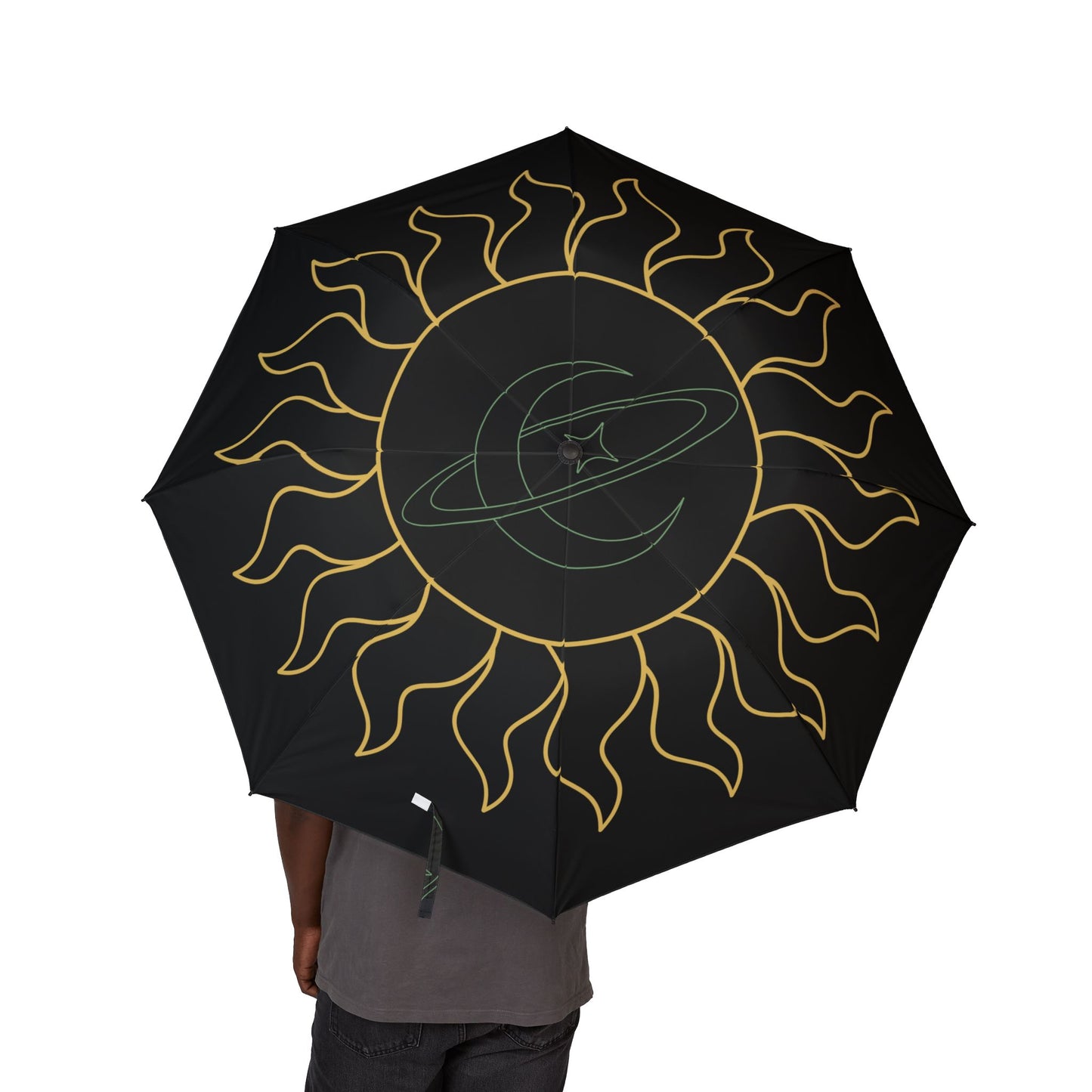 Black umbrella with gold sun design held by a person on a white background
