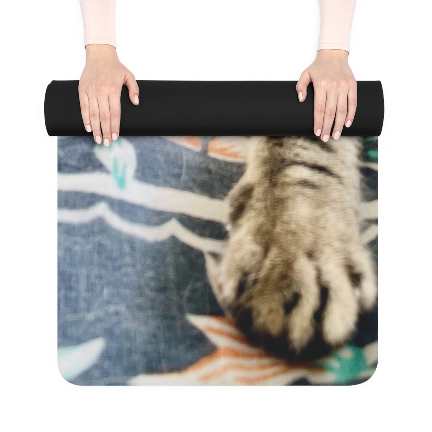 Person holding a black yoga mat with a colorful design underneath