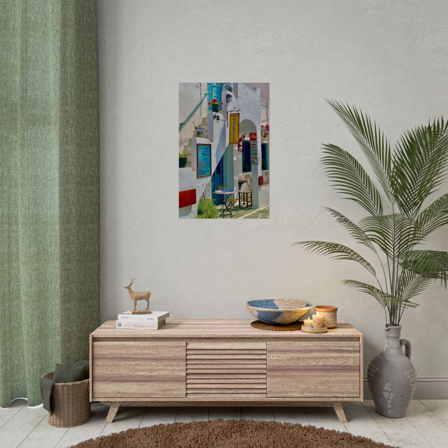 Wooden sideboard with decorative items against a light gray wall with a framed picture.