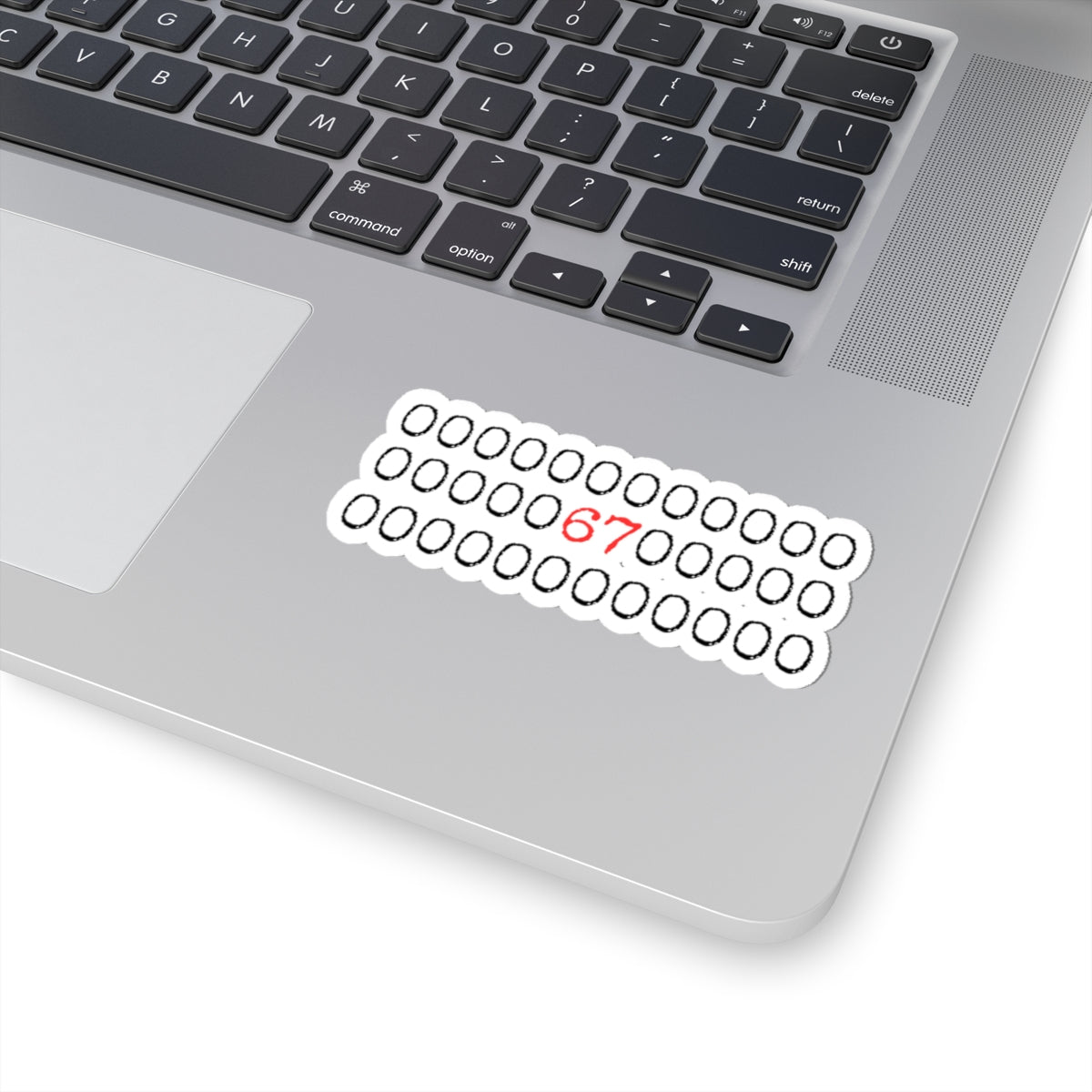 Laptop with a sticker featuring binary code and the number 67 on a white background