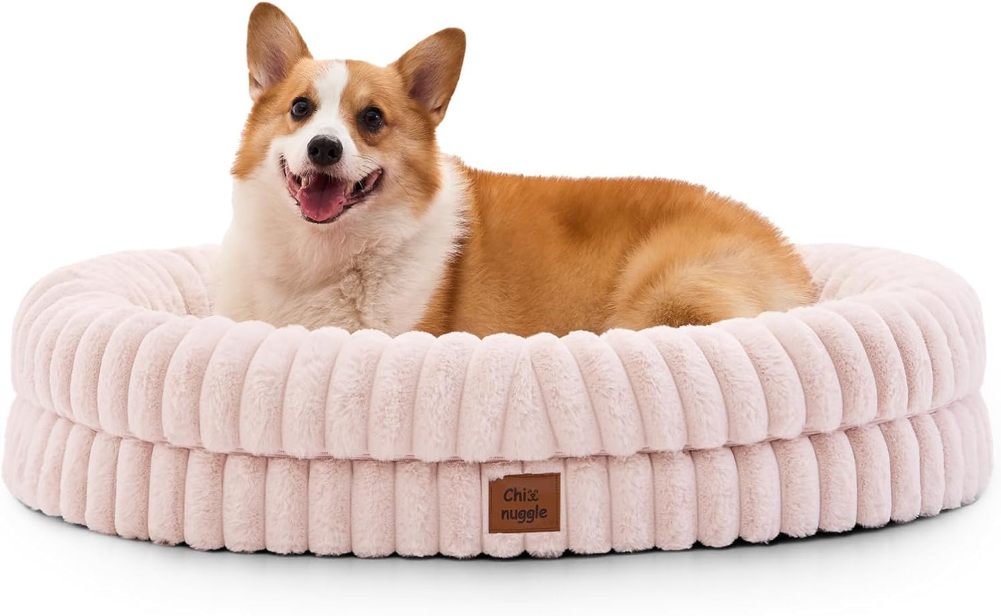 Dog lying on a fluffy pink pet bed with a visible brand label.