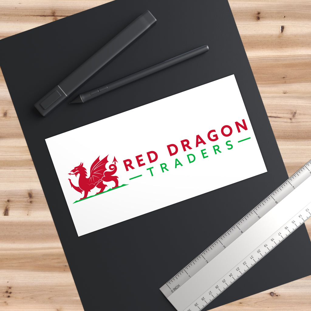 Black mat with 'Red Dragon Traders' logo, pens, and a ruler on a wooden surface