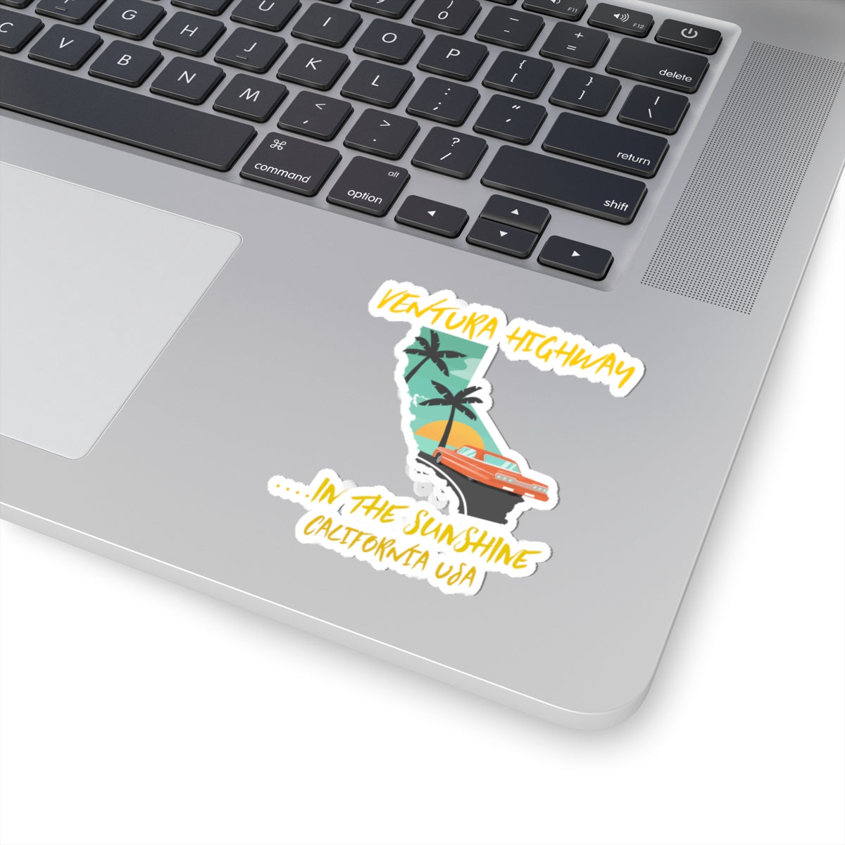 Laptop with a sticker of a stylized map of California and text on the palm tree design.