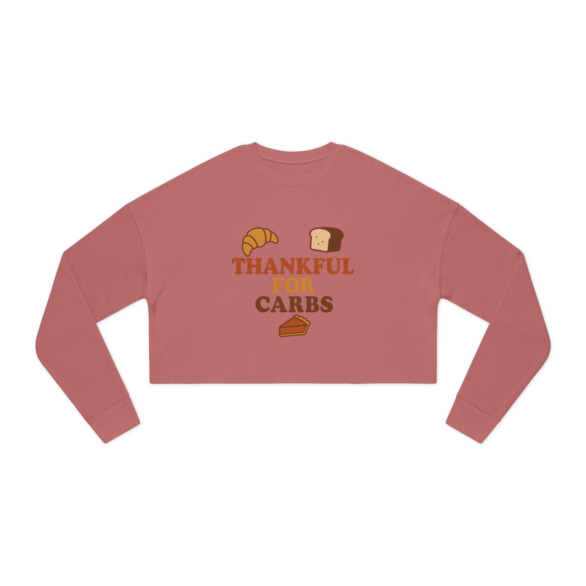 Pink long-sleeve crop top with 'Thankful for Carbs' text and food graphics on a white background