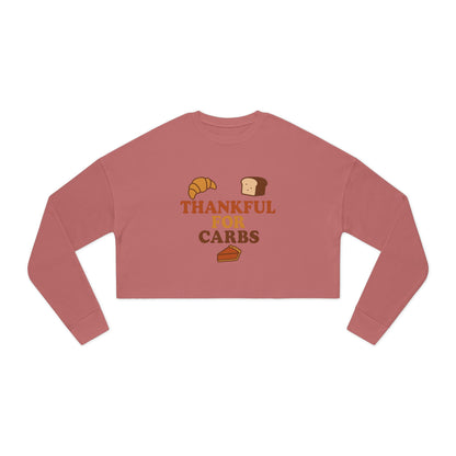 Pink long-sleeve crop top with 'Thankful for Carbs' text and food graphics on a white background