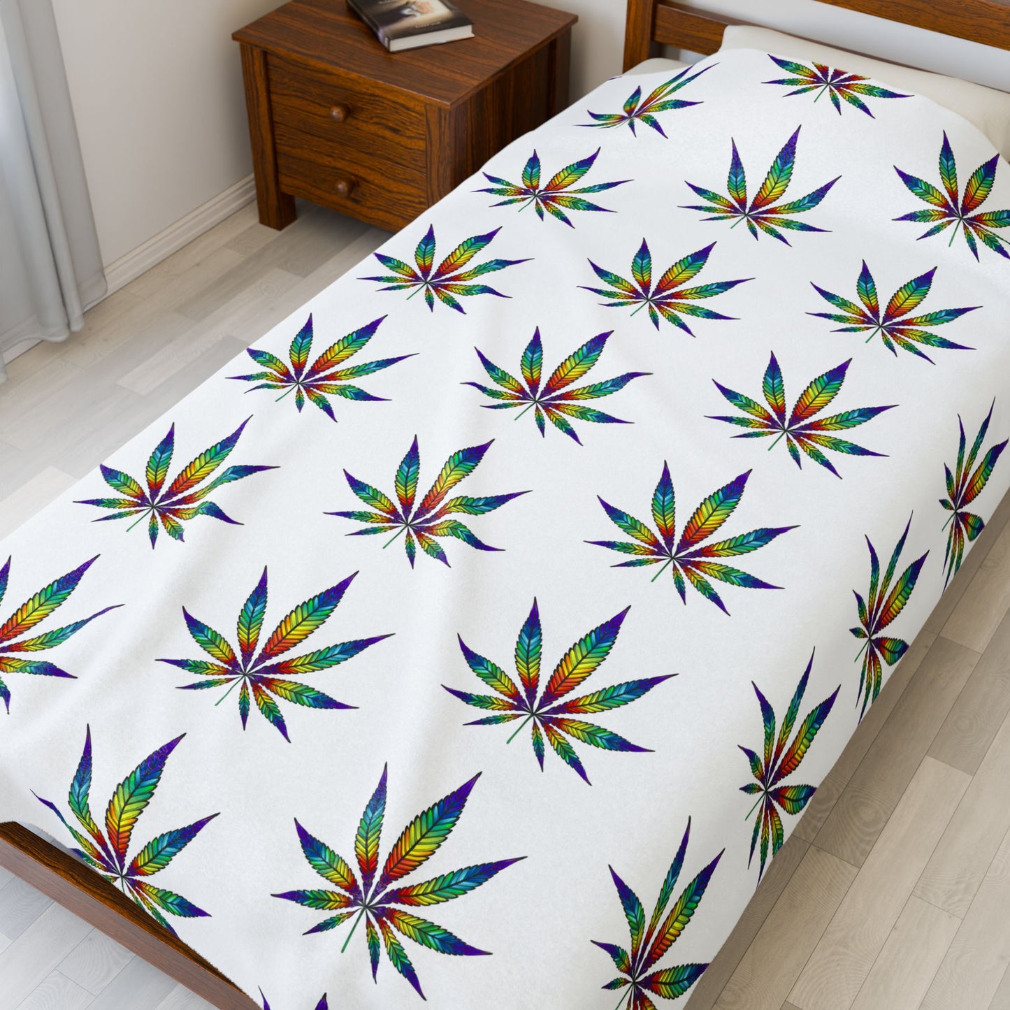 Cannabis Leaf Blanket with rainbow patterns on small bed 