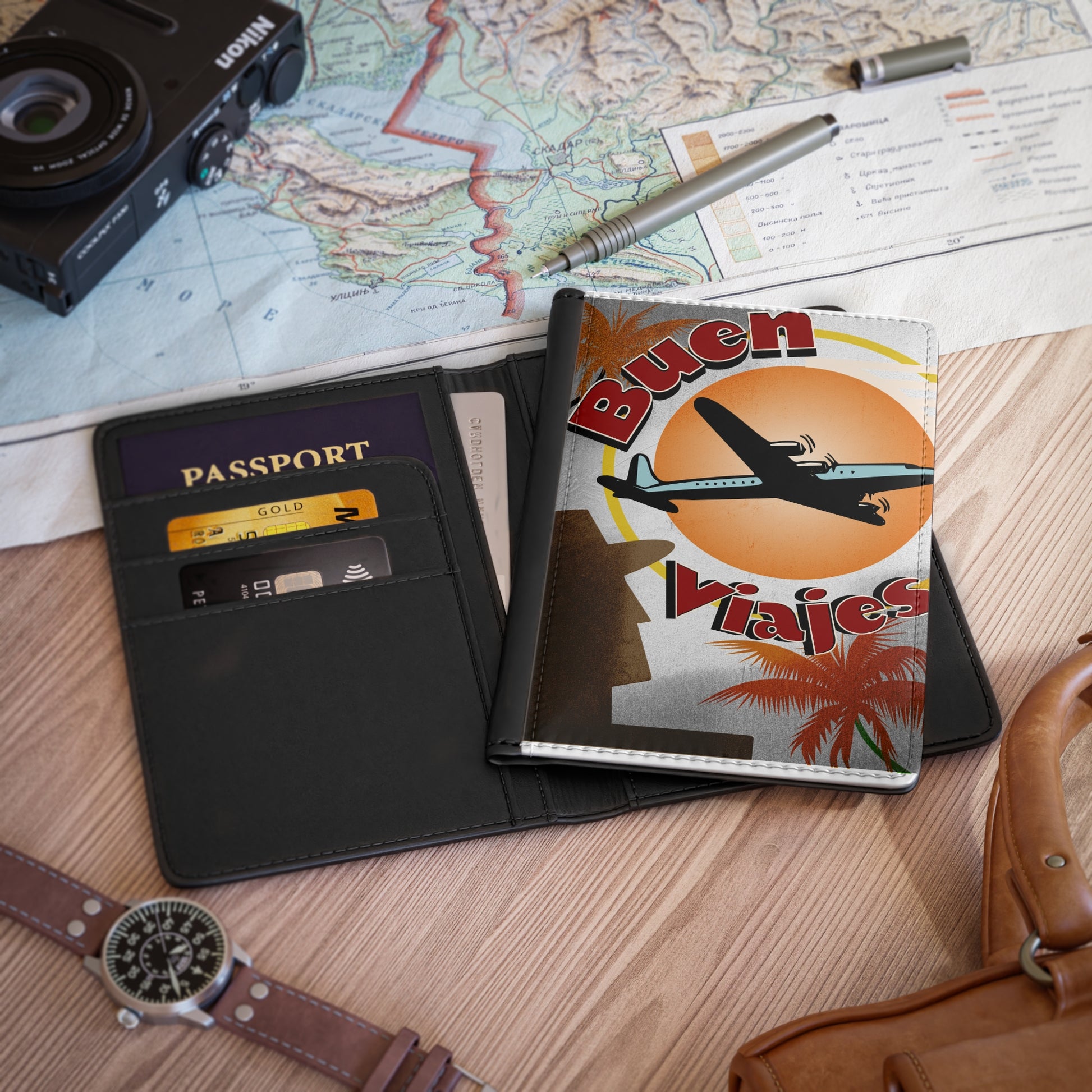 Passport, travel wallet, camera, and map on a wooden surface