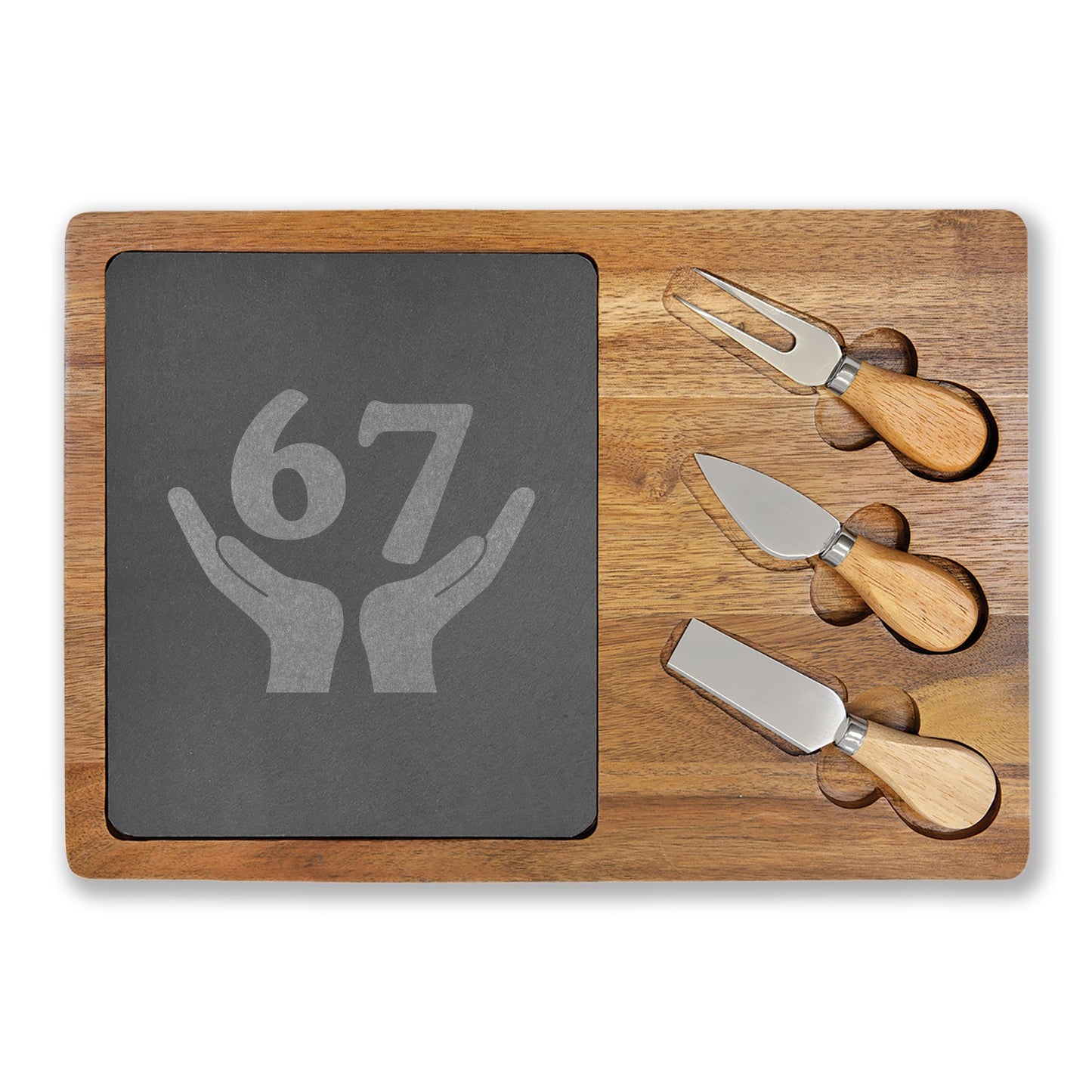 Wooden cutting board with a slate surface and three cheese knives on a white background