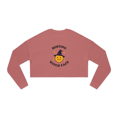 Pink long-sleeve crop top with 'Resting Witch Face' design on a white background