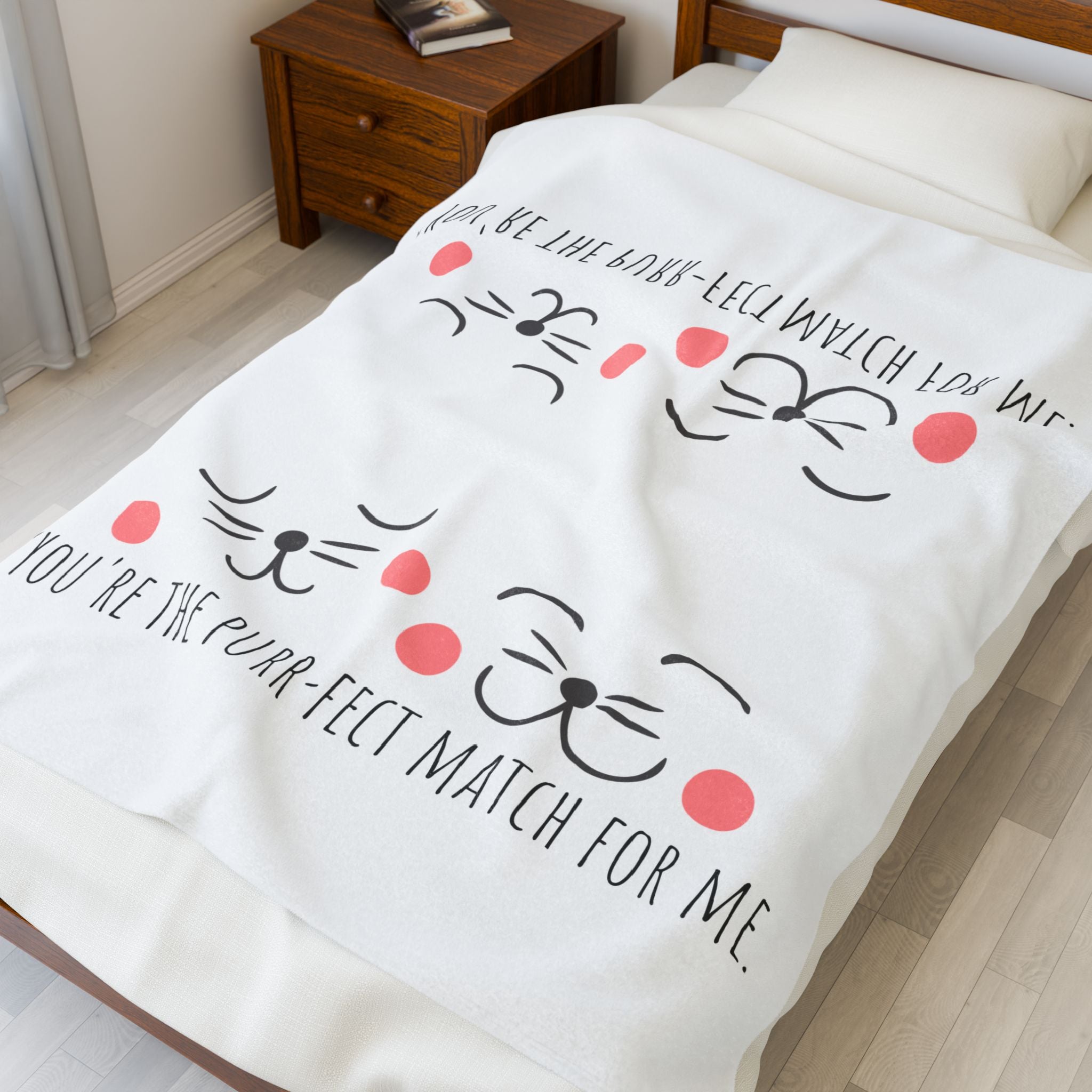 White cat-face plush blanket draped on a bed in a bedroom