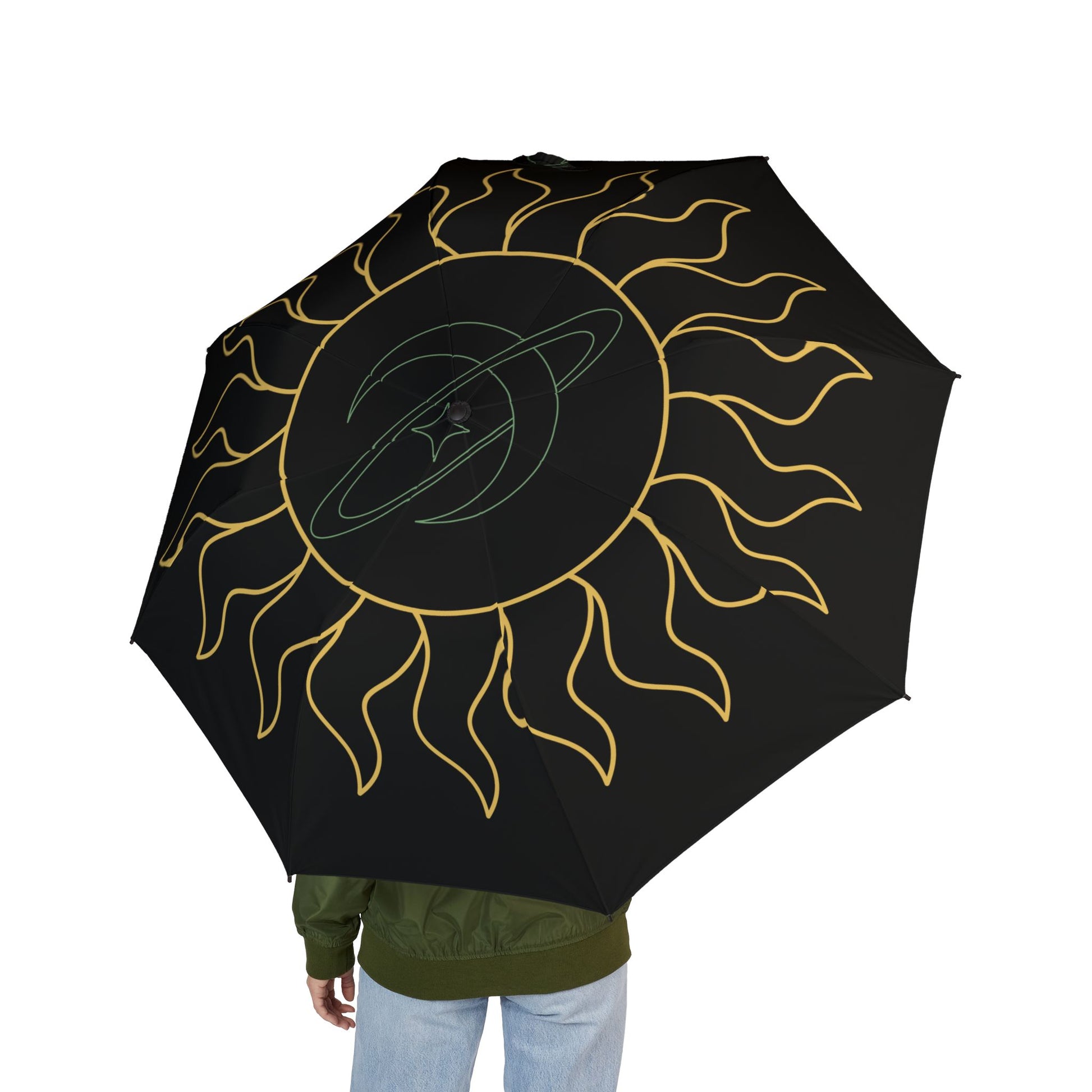 Black umbrella with gold sun design held by a person on a white background