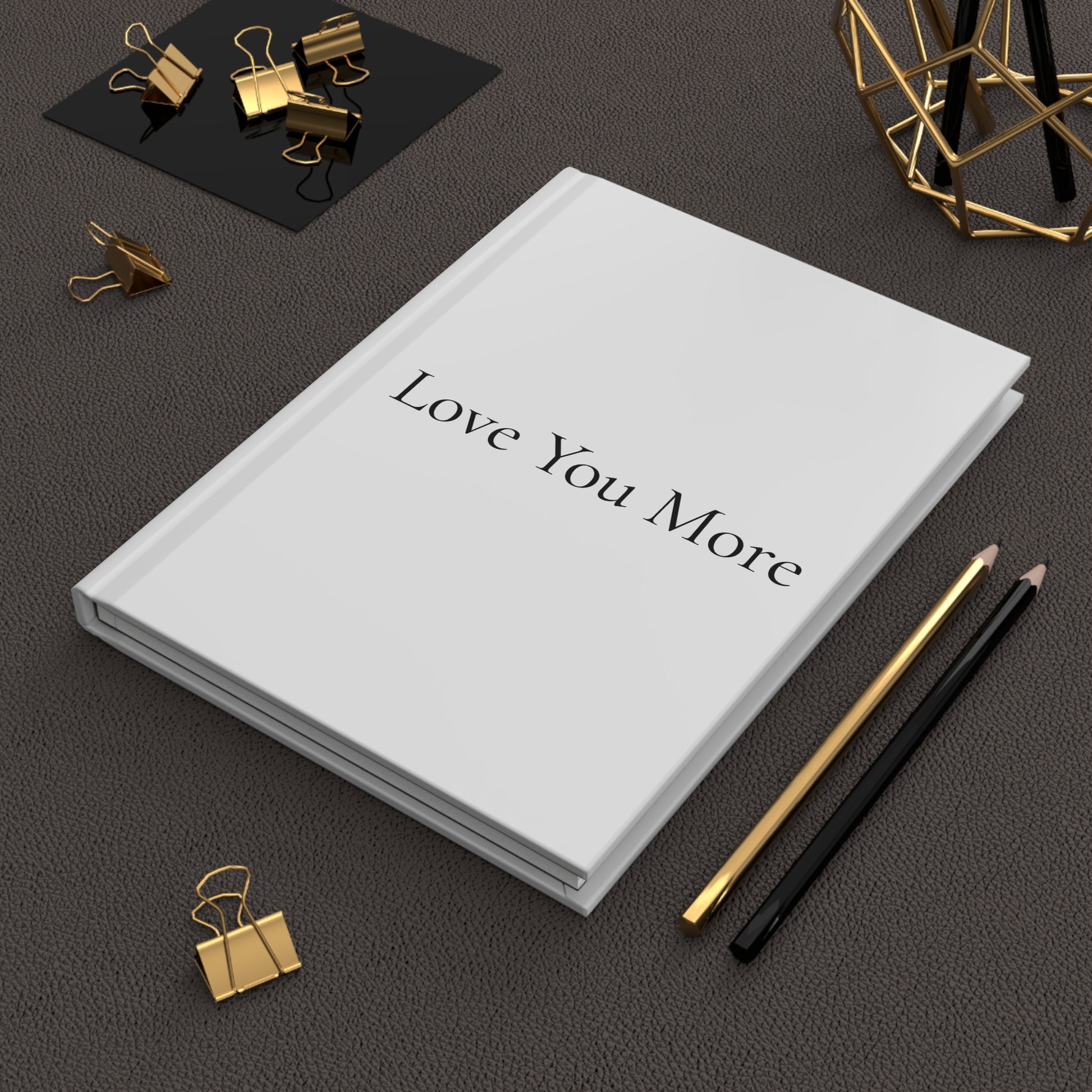 Journal lifestyle image with white cover and "Love you More" written on the cover