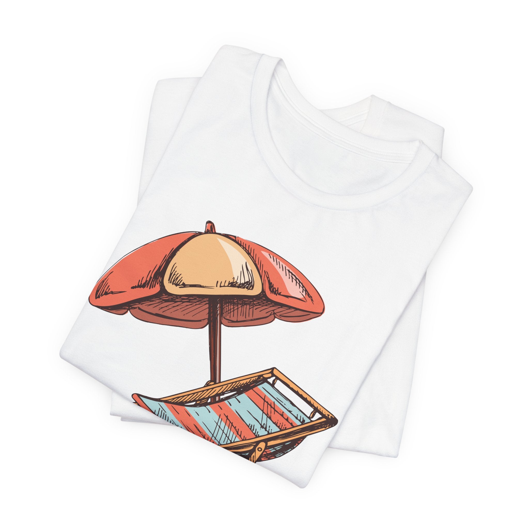 Folded white t-shirt showing a beach chair and orange umbrella graphic, on a white background