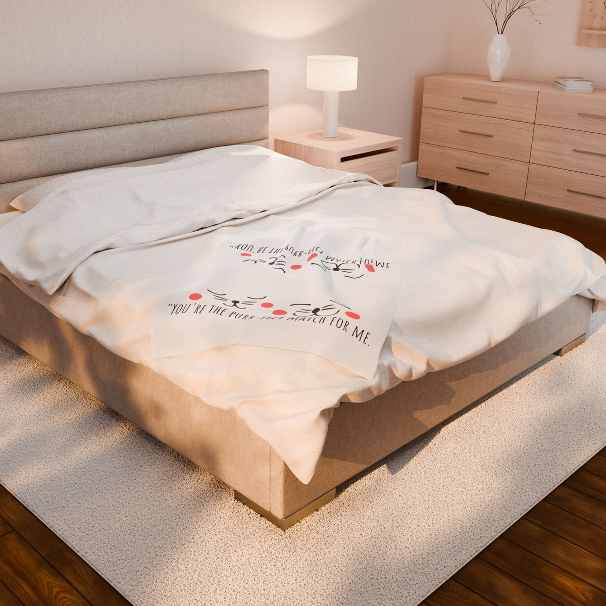 White cat-face plush blanket draped over a bed in a styled bedroom