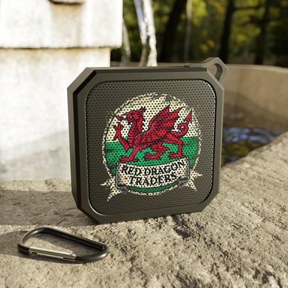Black portable speaker with red dragon design on a stone surface