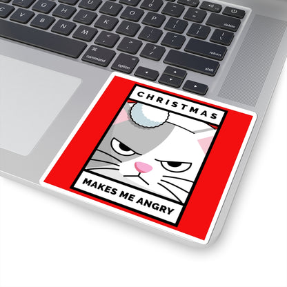 Laptop with a sticker of a cat's face and text 'Christmas makes me angry' on a red background.