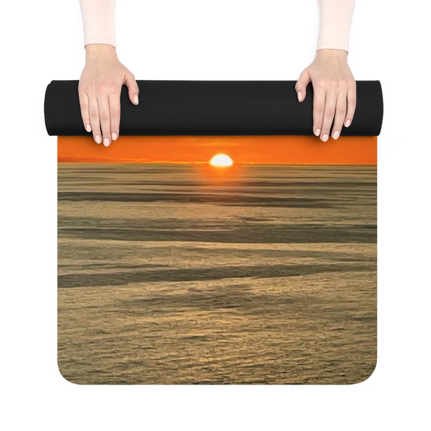 Yoga mat with sunset design held by hands on a white background