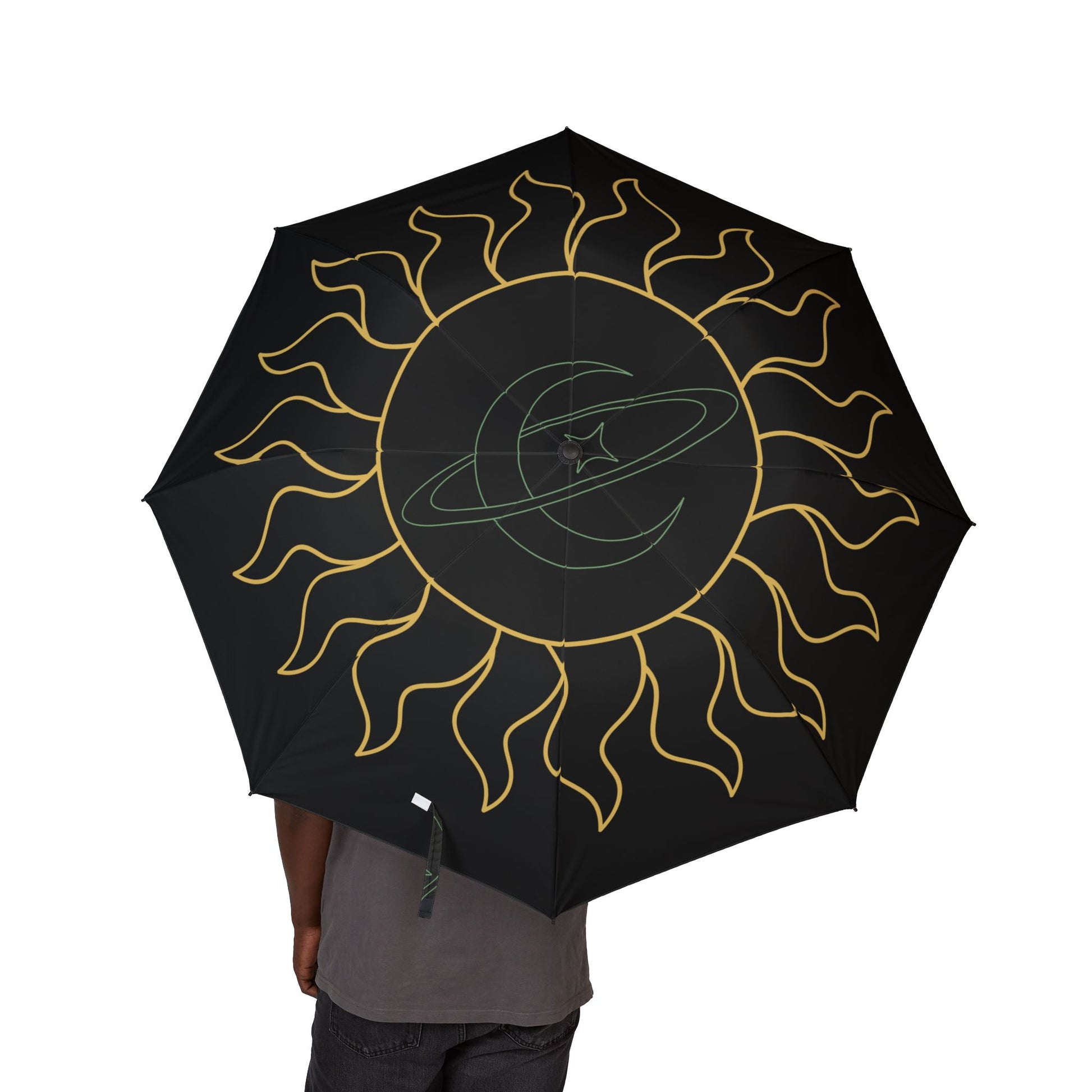 Black umbrella with gold sun design held by a person on a white background