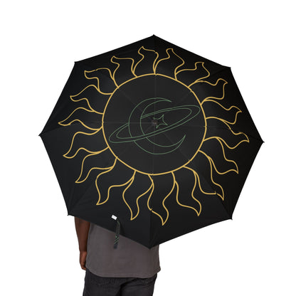 Black umbrella with gold sun design held by a person on a white background