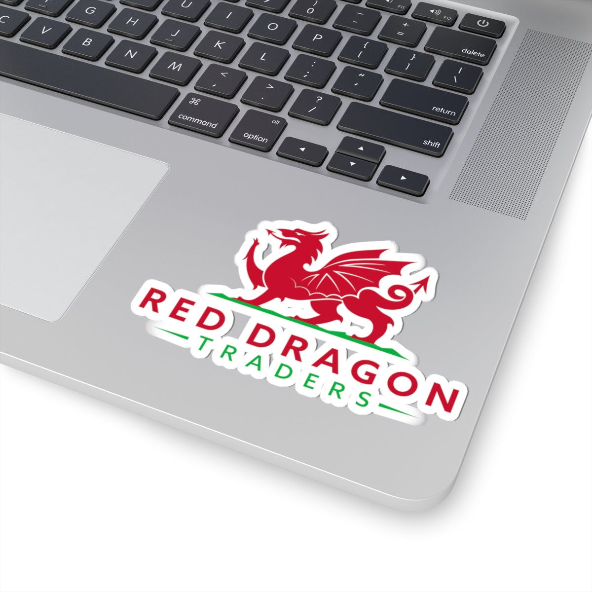 Laptop with a 'Red Dragon Traders' sticker on the palm rest area