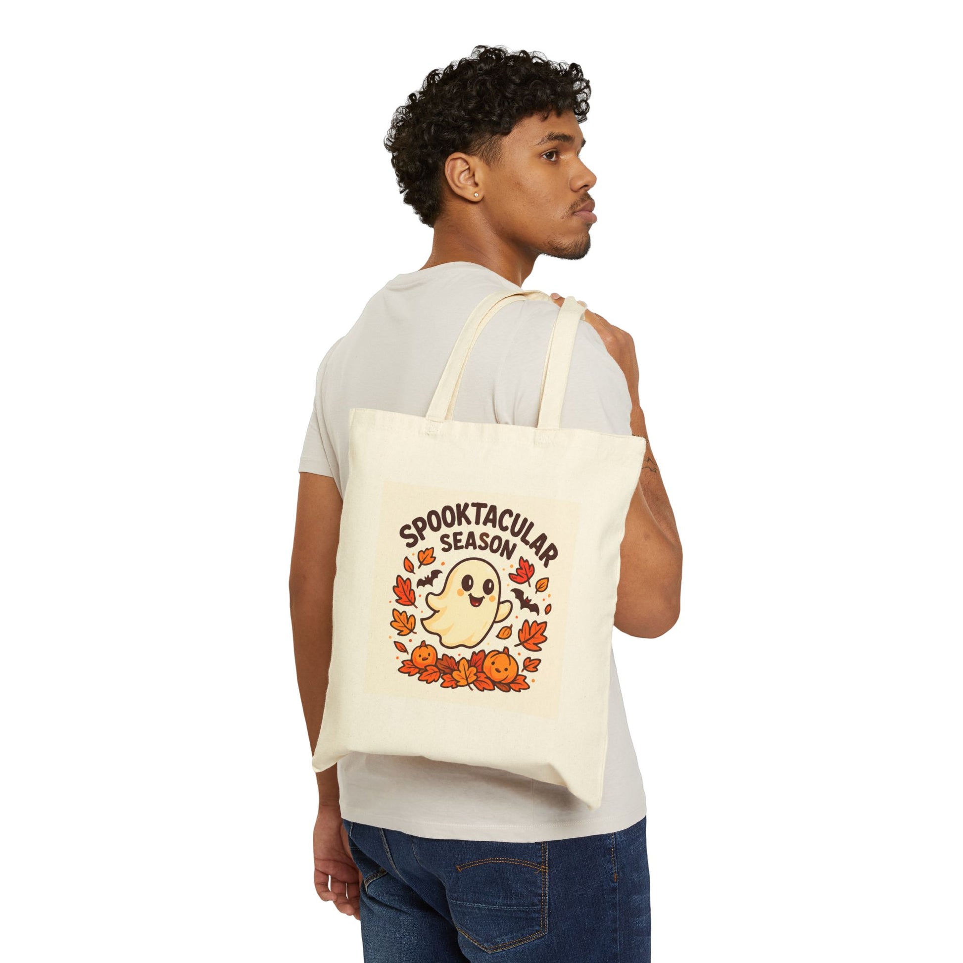 Person holding a tote bag with 'Spooktacular Season' design on a white background