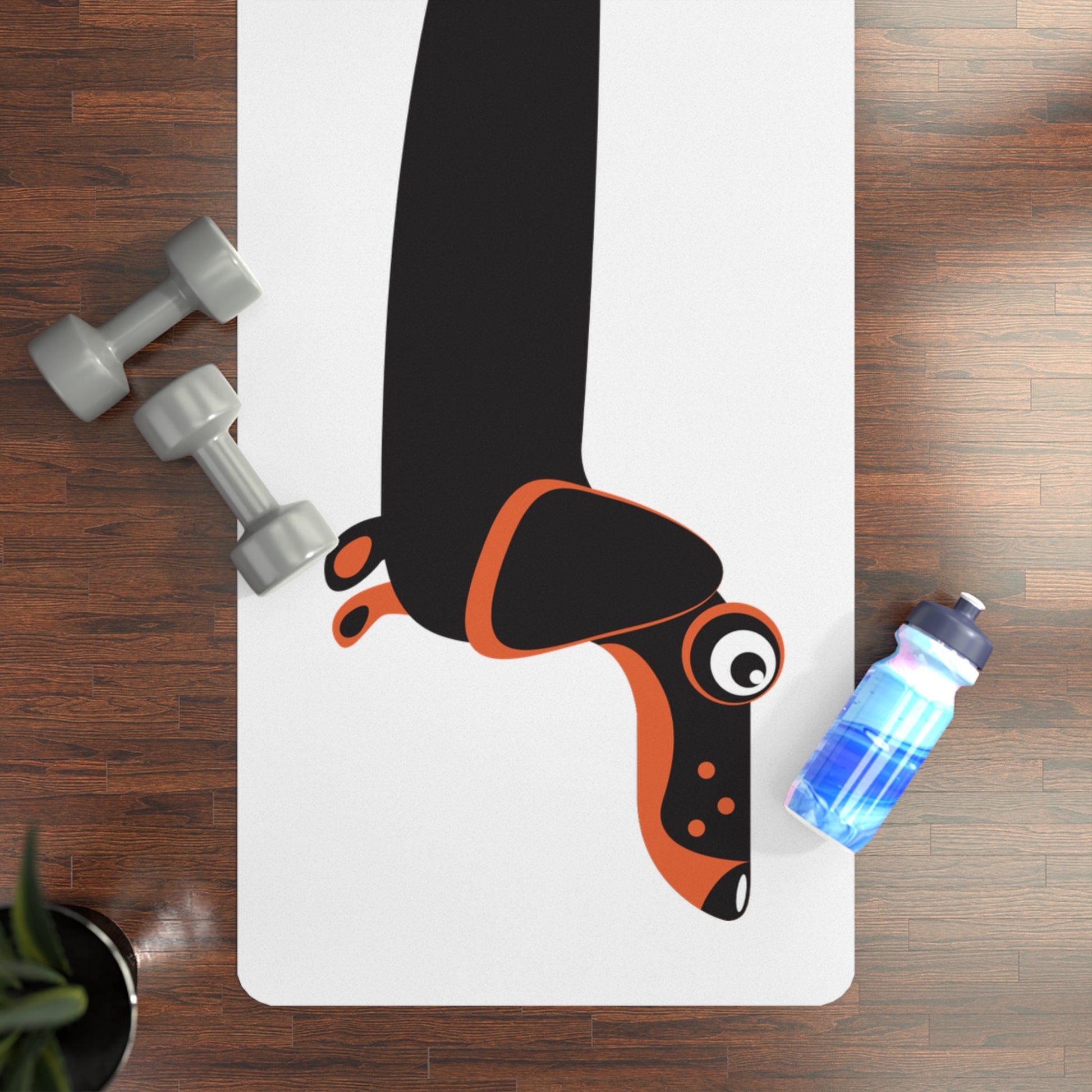 Yoga mat with cartoon dachshund dog, dumbbells, and water bottle on a wooden floor