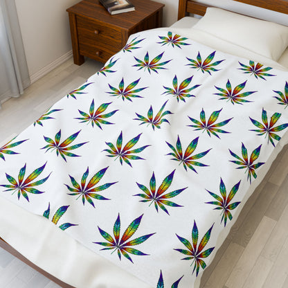 Cannabis Leaf Blanket with rainbow patterns laying on bed 