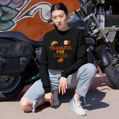 Person wearing a black sweatshirt with text, sitting next to a motorcycle.