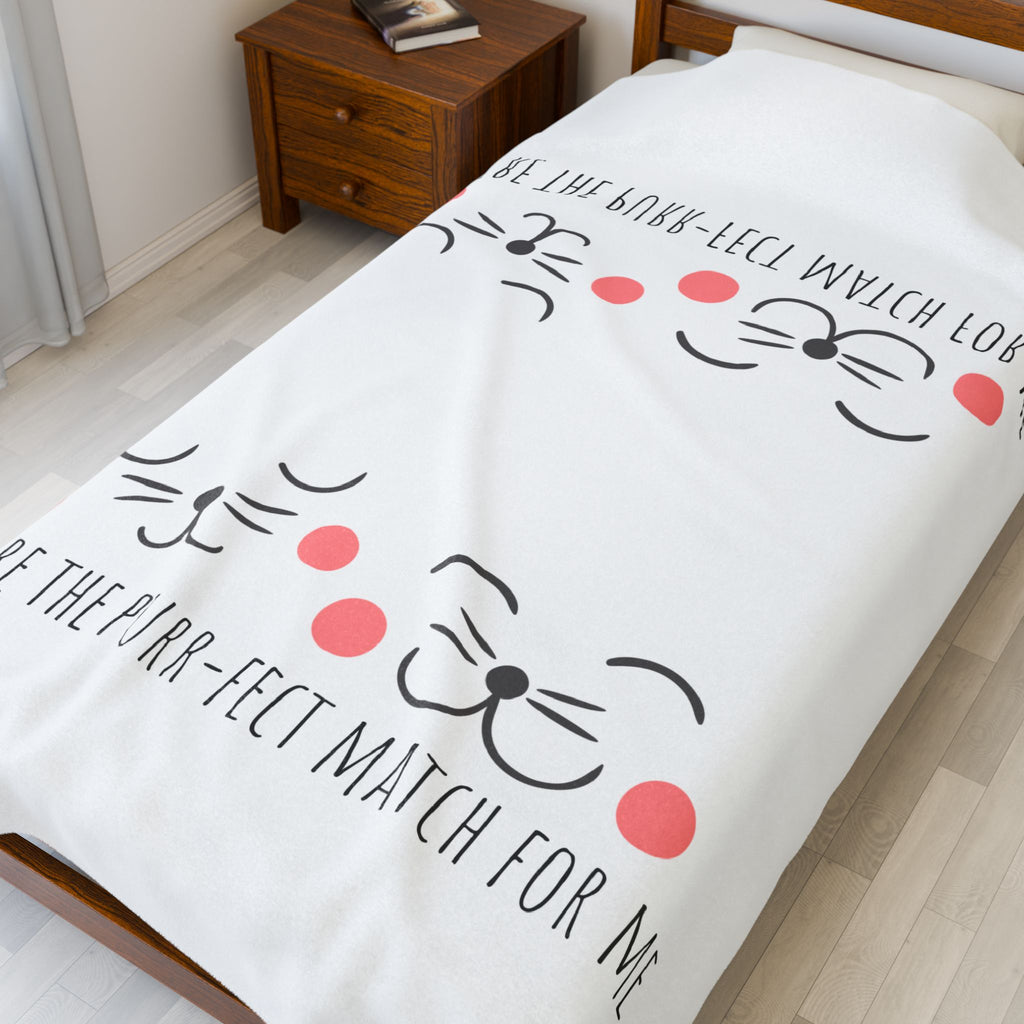 White 'Purr-fect Match' cat blanket spread on a bed