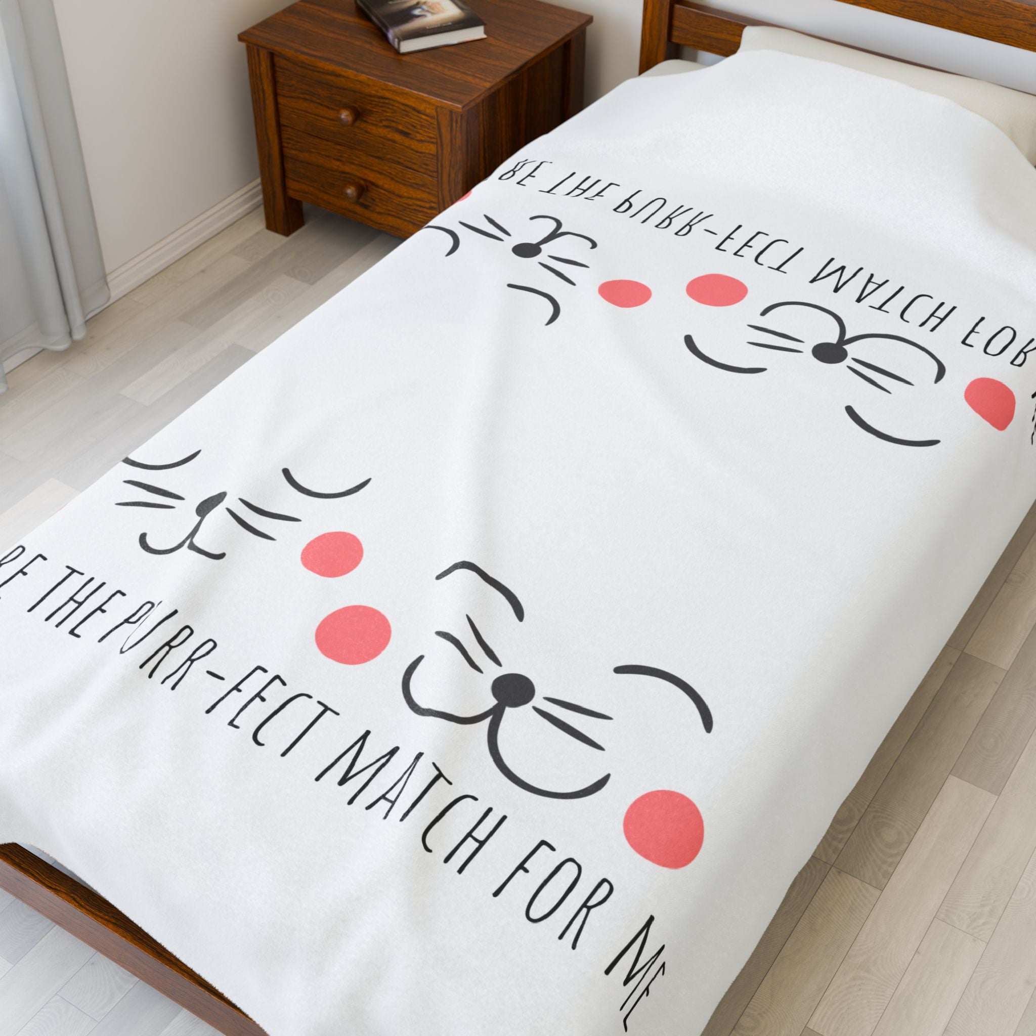 White 'Purr-fect Match' cat blanket spread on a bed