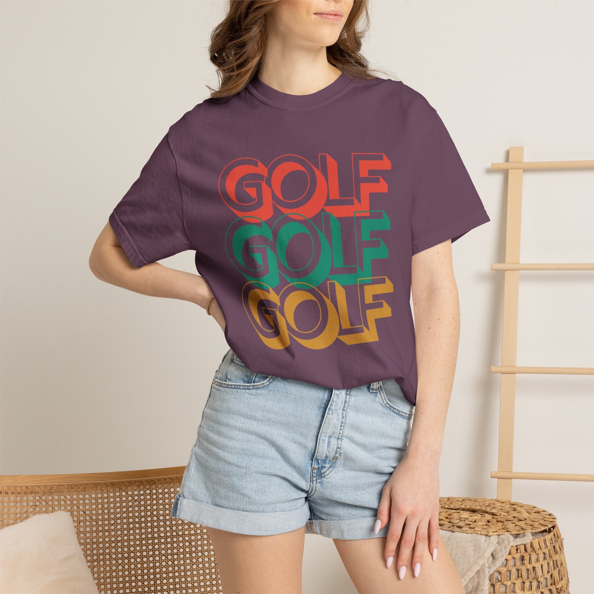 Person wearing a gray t-shirt with 'GOLF GOLF GOLF' text in multiple colors.