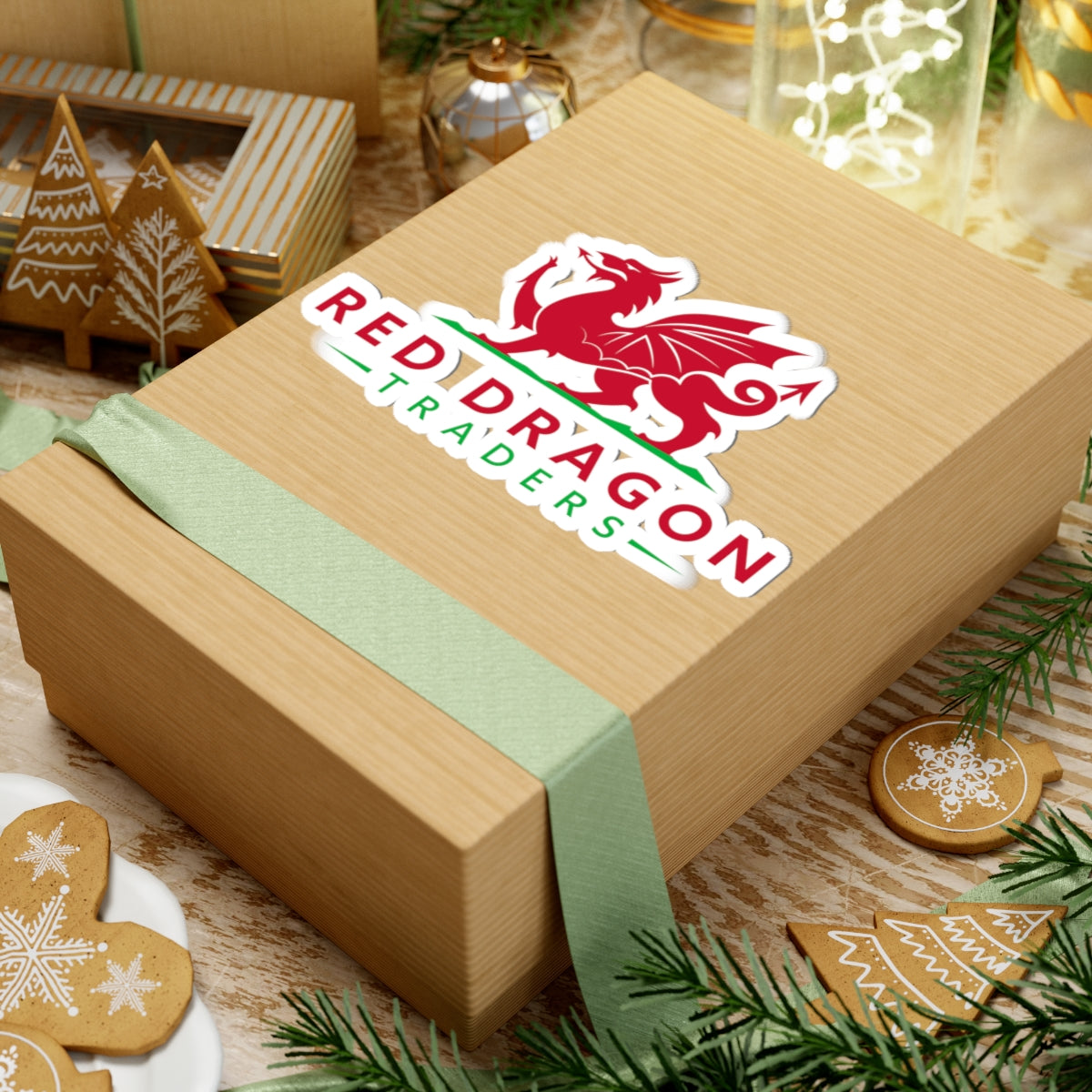 Wooden gift box with a green ribbon and Red Dragon Traders logo on a festive background with cookies and Christmas decorations.