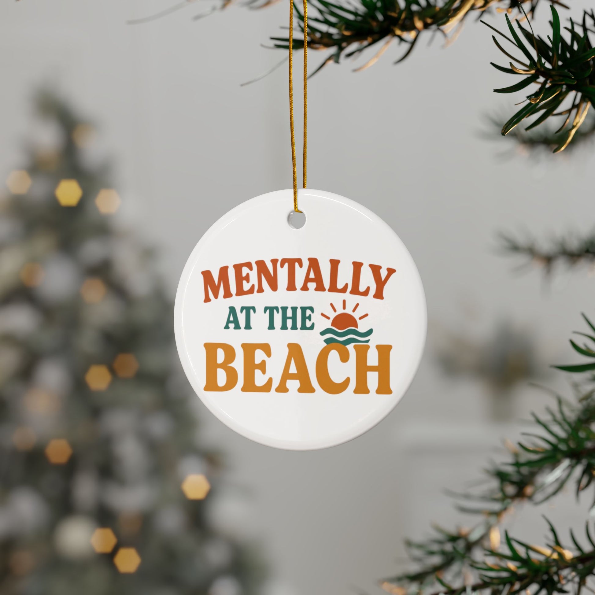 Decorative ornament with 'Mentally at the Beach' text hanging on a Christmas tree.