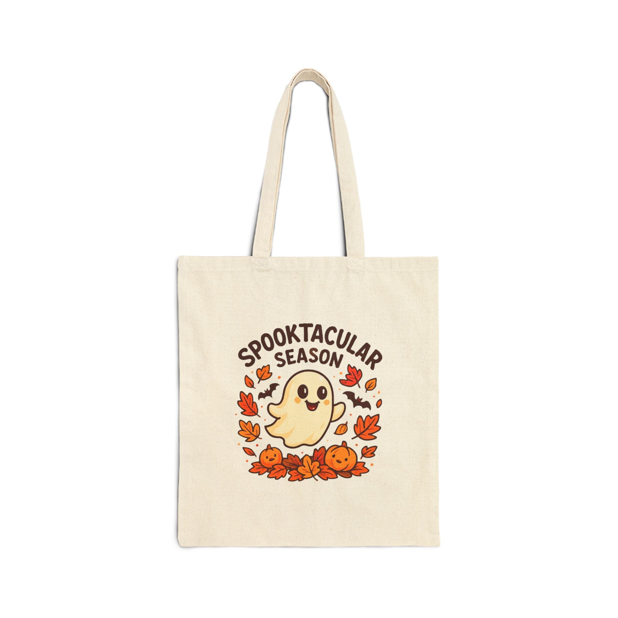 Natural canvas tote bag with a cartoon ghost, autumn leaves, and pumpkins beneath the words Spooktacular Season, on a white background.