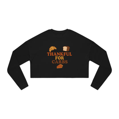 Black long-sleeve crop top with 'Thankful for Carbs' text and food graphics on a white background