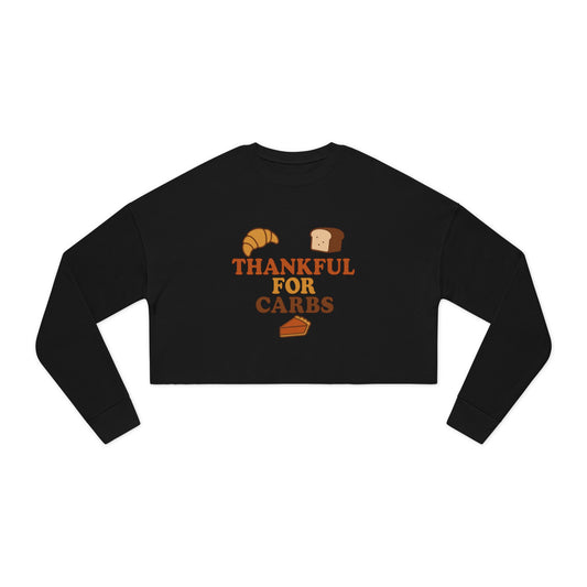 Black long-sleeve crop top with 'Thankful for Carbs' text and food graphics on a white background
