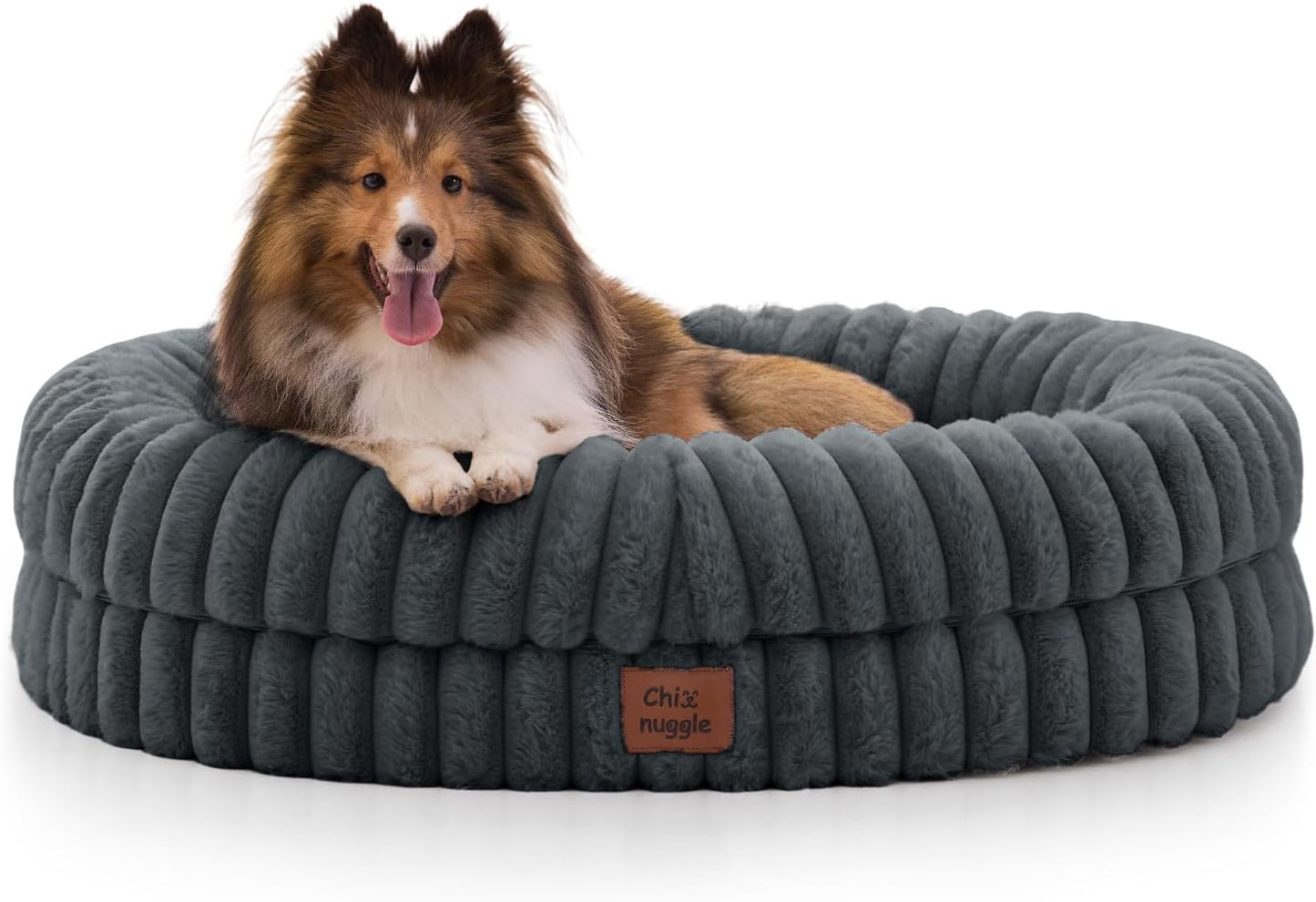 Dog lying on a gray plush dog bed with a visible brand label.
