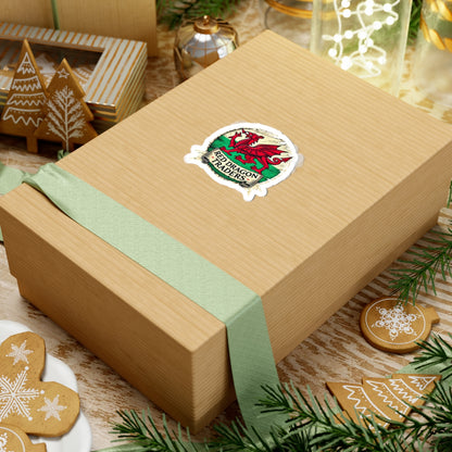 Gift box with a green ribbon and a logo on a festive background with cookies and decorations.