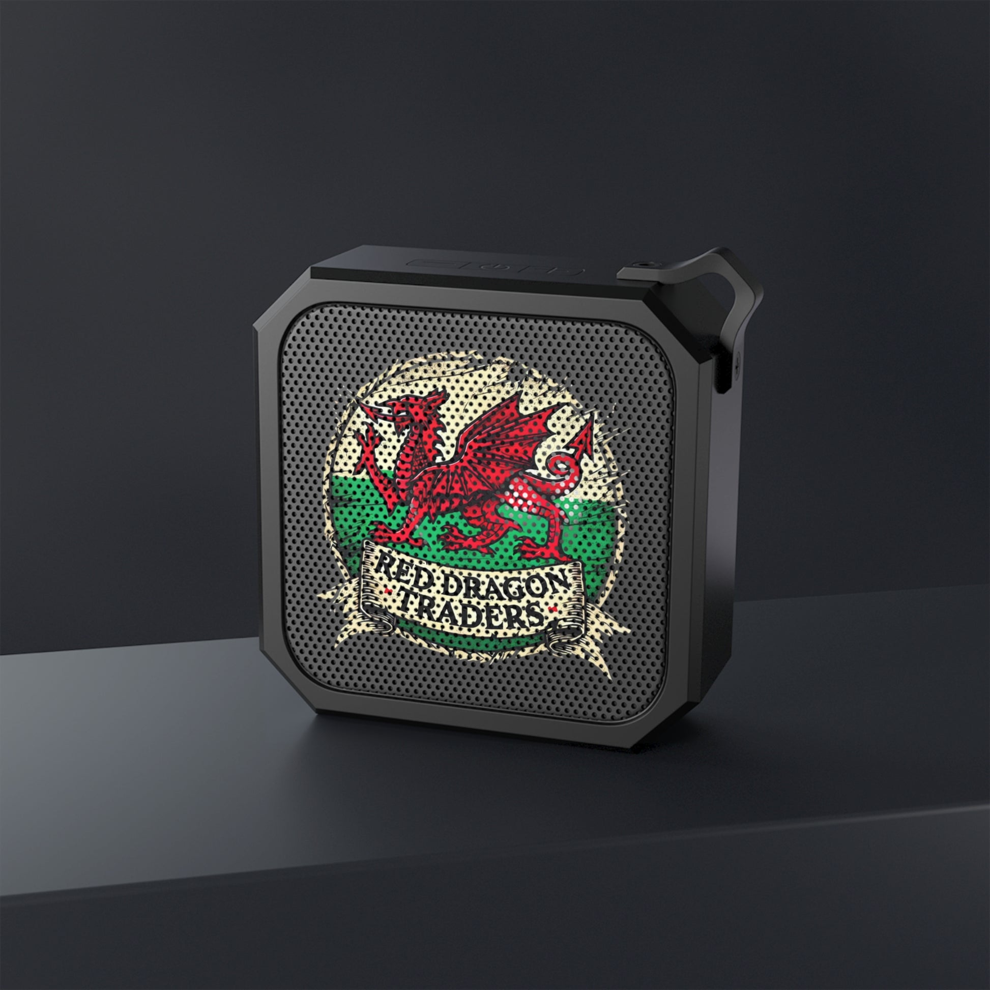 Black portable speaker with red dragon design on a dark background