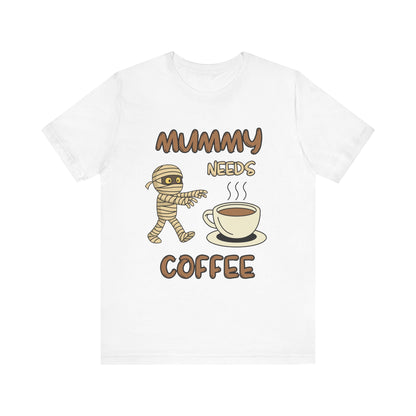 White t-shirt with a mummy graphic and coffee cup, text 'Mummy Needs Coffee' on a white background