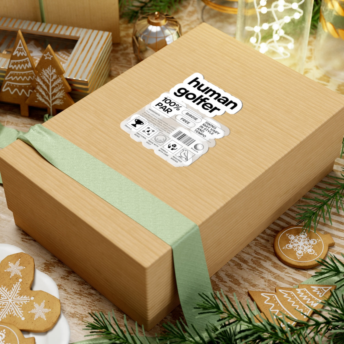 Wooden gift box with a green ribbon and 'human golfer' label, surrounded by festive decor.