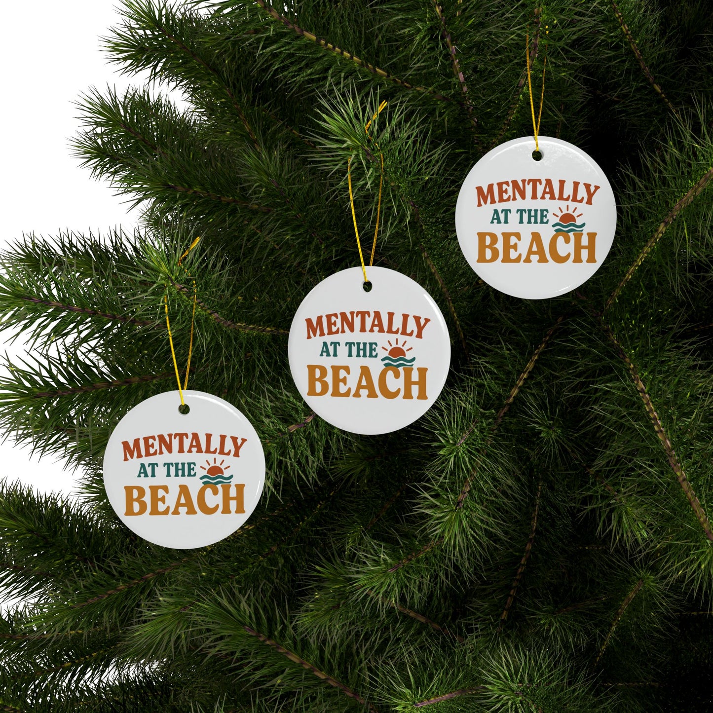 Three 'Mentally at the Beach' Christmas ornaments hanging on a tree.