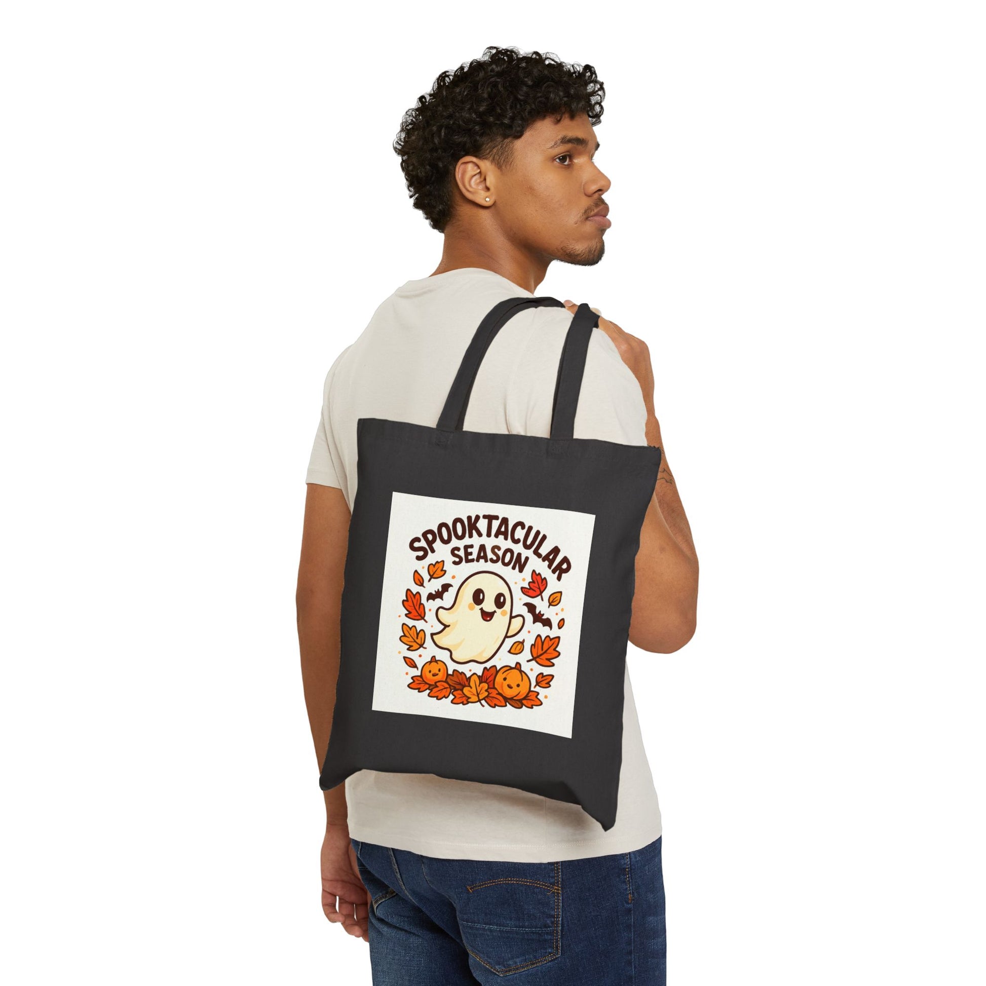 Person wearing a black tote bag with a Halloween design on a white background