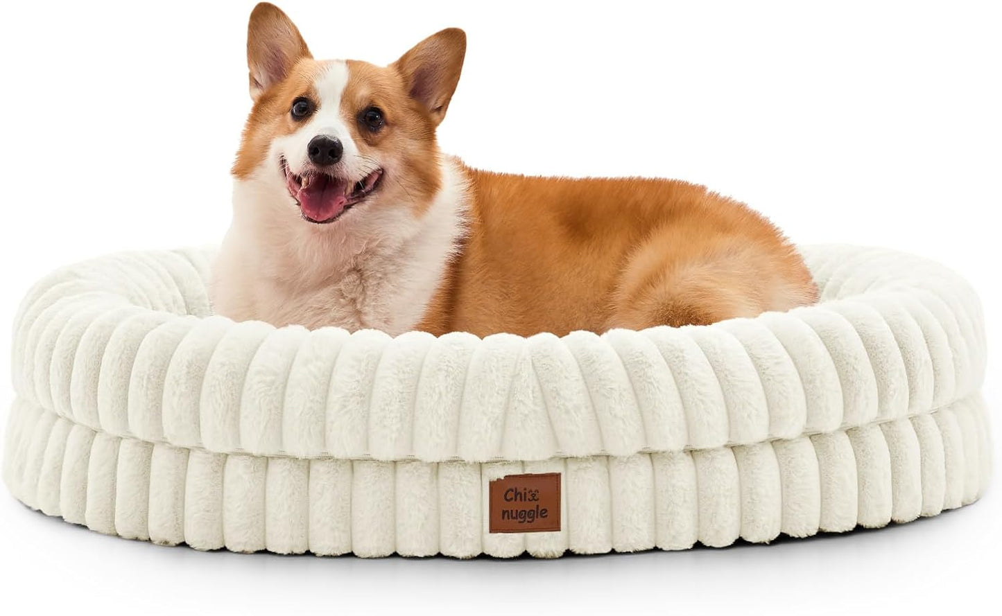 Dog lying on a fluffy white pet bed with a visible brand logo.