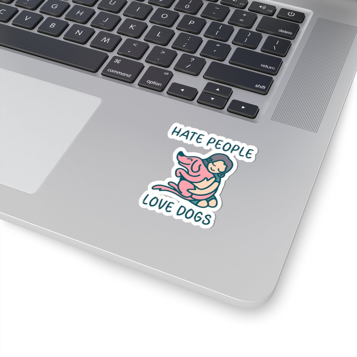 Laptop with a sticker that reads 'Hate people, love dogs' on the palm rest area.