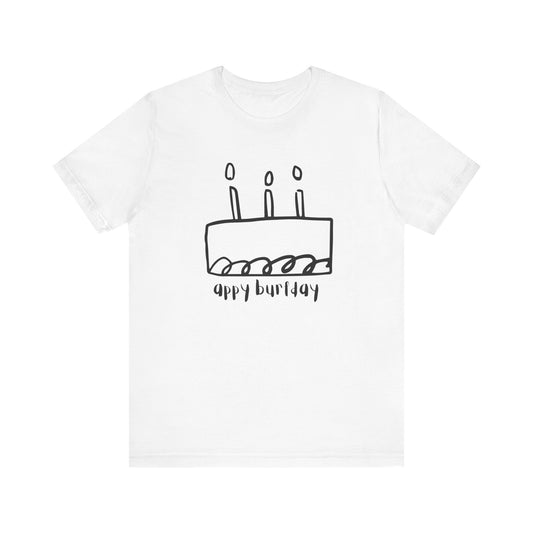White t-shirt with a black birthday cake graphic and 'Appy Burfday' text on a white background