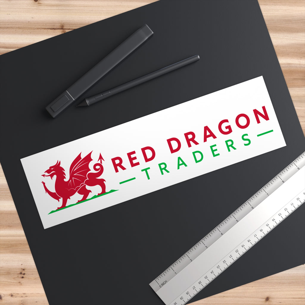 Sticker with 'Red Dragon Traders' logo on a black surface with pens and a ruler.
