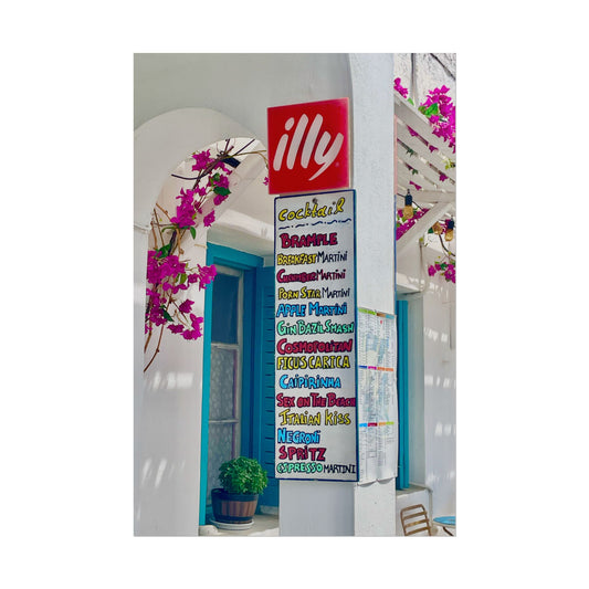 Illy coffee sign with a colorful cocktail menu in a bright outdoor setting